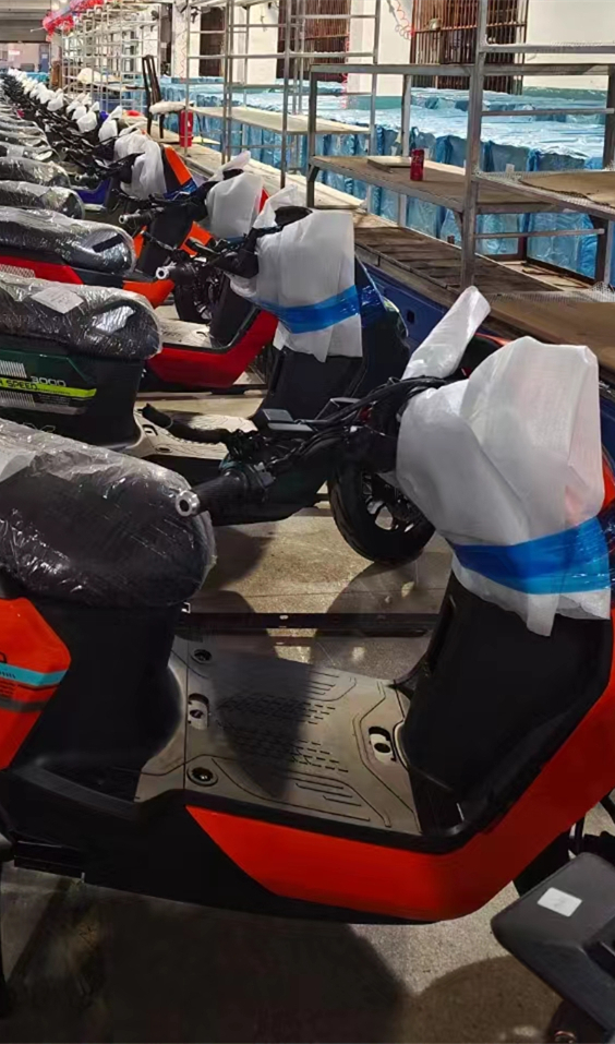 Partially packaged electric motorcycles assembled beside the assembly line